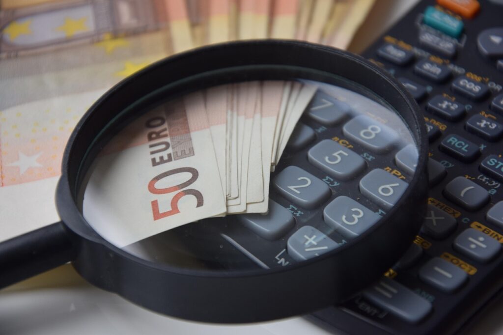 magnifying glass, money and a calculator