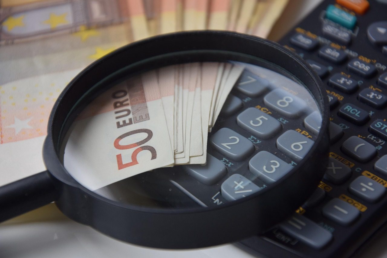 magnifying glass, money and a calculator